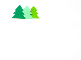 Fototapeta premium Three multi-colored silhouettes of Christmas trees on a white background, copy space
