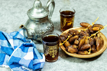 Traditional Moroccan Mint Tea with silver teapot, Arabic drink and  ripe dates 