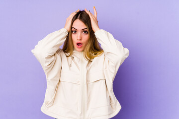 Young caucasian woman isolated on purple background being shocked, she has remembered important meeting.