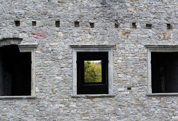 Fototapeta na wymiar Old, historical and antique wall made of stone. Facade with windows and frame. Minimalist detail of aged architecture and building. 