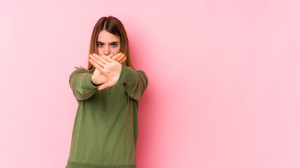 Obraz premium Young caucasian woman isolated on pink background doing a denial gesture