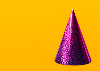 Cone cap Close up photo template with copy space Bright shiny lilac party cap on yellow background Minimal style
