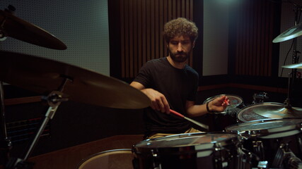 Artist hitting drum cymbals in studio. Drummer performing solo in concert hall.