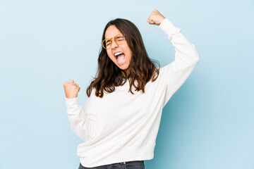 Young mixed race hispanic woman isolated raising fist after a victory, winner concept.