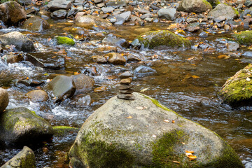 Fototapeta na wymiar View of a creek with stacked stones on a rock