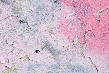 Pink spray paint on cracked rough concrete wall.