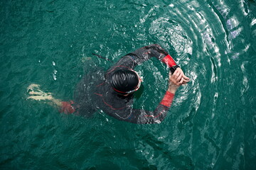 triathlon athlete swimming on lake setting smartwatch