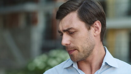 Naklejka premium Portrait businessman finishing phone talk at street. Man looking away at street
