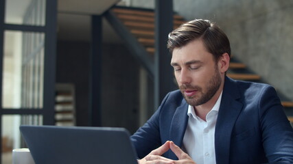 Fototapeta premium Joyful businessman making web call on laptop camera. Guy making conference call