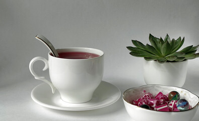 Fruit tea in a white cup with sweet candies