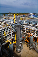 Grey distillation tower, pipelines and pipes. Oil refinery and gas processing plant. Blue sky....