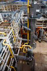 Oil refinery and gas processing plant. Grey distillation tower (refining column). Wide angle. Pipelines and pipes background. Uralsk region, Kazakhstan.
