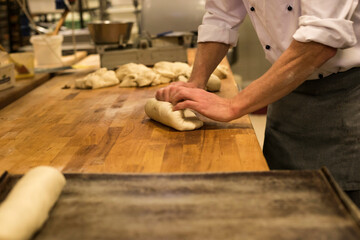 Baker kneading dough in a bakery