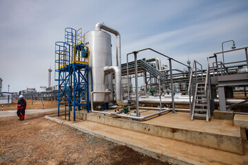 Refinery equipment, pipes, pipelines and worker or engineer. Oil refinery and gas processing plant. Uralsk region, Kazakhstan.