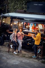 Group of friends eating fast food together; Urban lifestyle concept