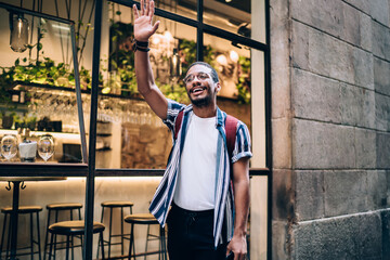 Joyful ethnic man standing outside cafe © BullRun