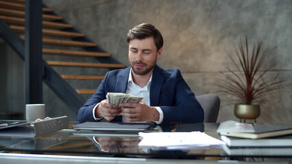 Smiling man counting money at workplace in slow motion. Guy made easy money.