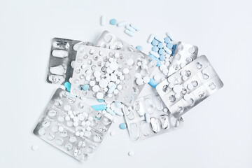 blue pills and capsules in blisters on of white background. composition on a medical theme. simple flat lay, top view