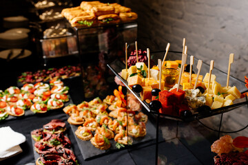 Tasty food and drink on black table for event