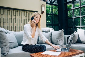 Content female entrepreneur having conversation on cellphone