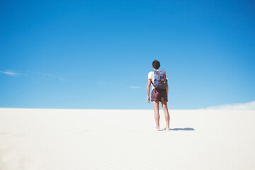 Male traveler standing on sand dunes
