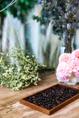 Roasted coffee beans in  behind beautiful flower background.
