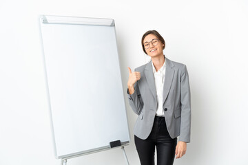Young Ireland woman isolated on white background giving a presentation on white board and with thumbs up