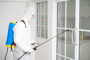 health care worker in white jumpsuit and protective face mask using spraying machine to disinfect virus pandemic.  Health care and midicine concept. New normal social distancing concept.