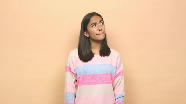 Young mixed race indian woman confused, feels doubtful and unsure