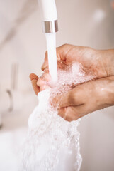 Washing Hands with streaming water under tap in bathroom. Hygiene,Hand washing. woman washing hands under a tap water
