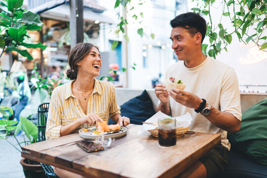 Diverse couple having fun at table in cafe