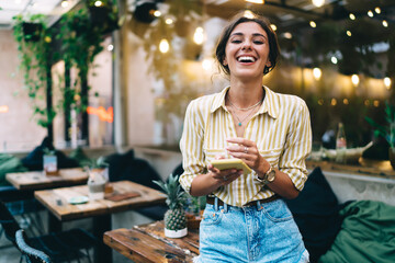 Laughing woman surfing internet on smartphone
