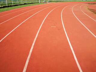 curve of running track. Tartan track in red with white lines. Selective focus
