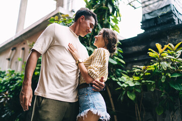 Happy diverse couple hugging each other on street in tropical place