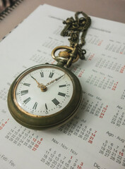 Reloj de bolsillo sobre calendario anual