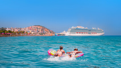 Girls in bikini lying on air bed -    The cruise ship is located on Kusadasi Island in the port of...