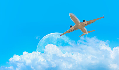 White passenger airplane in the clouds with full moon  - Travel by air transport 
