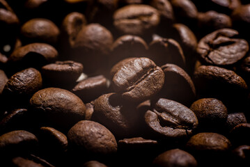 Closeup macro a group roasted brown or black coffee beans background