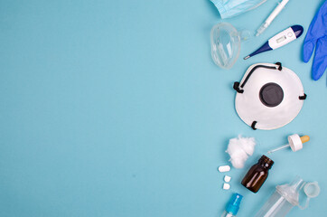 facemask and other medical objects on a blue background, with space for text on the left.  Aerial photography.