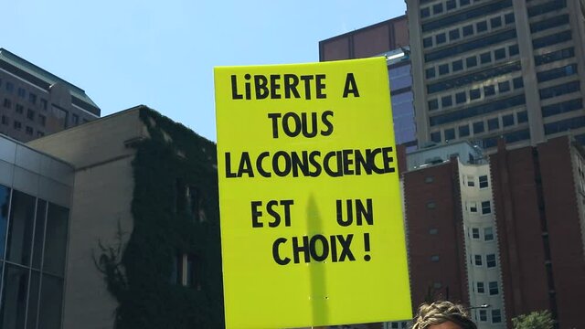 Selective focus of yellow banner with text and message written in french meaning freedom to all conscience is a choice during protest on street