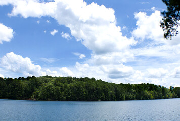 Beautiful white clouds and blue sky over peaceful lake.