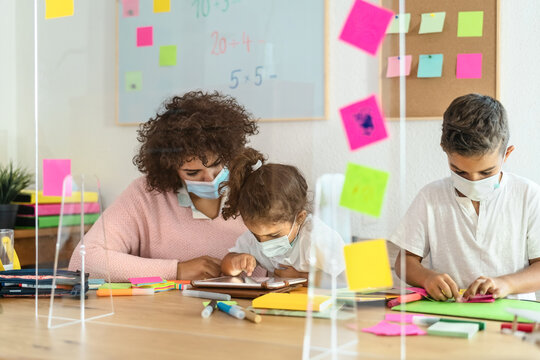 Teacher With Children Wearing Face Mask In Preschool Classroom During Corona Virus Pandemic - Healthcare And Education Concept