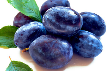 fresh ripe plums isolated on white close up, selective focus