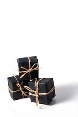 Pyramid of black handmade gift boxes tied with craft thread. Isolated. smart gift concept. copy space. vertical frame