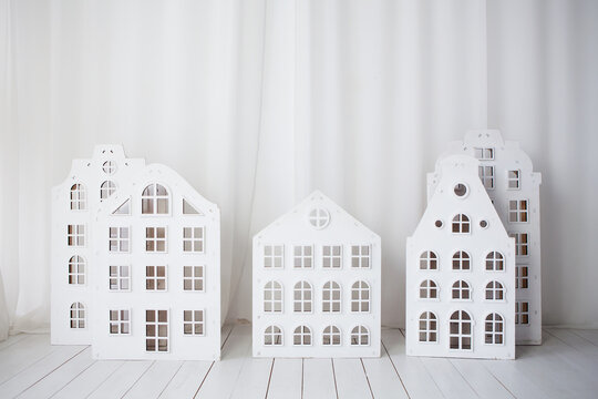 White wooden toy houses on light backgound. Mortgage property insurance dream home concept.