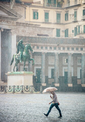 jour de pluie, homme sous un parapluie sur une place