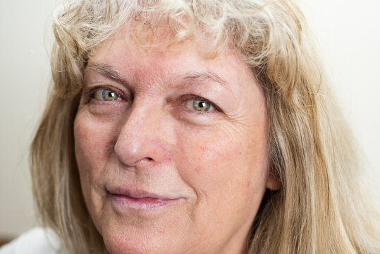 Closeup photography of real middle age caucasian woman with beautiful green eyes looking to the camera.