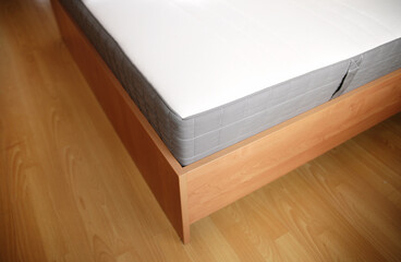 closeup view of wooden bed and white matters in the hotel