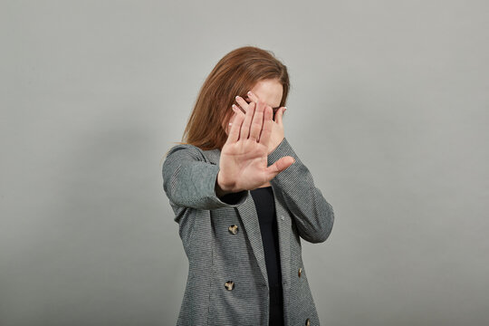Palm arm raised air angry look straight you will not pass through facial expression harsh. Serious looking strict demands stop, pulls hand forward camera, says no, disagrees, frowns face, warning