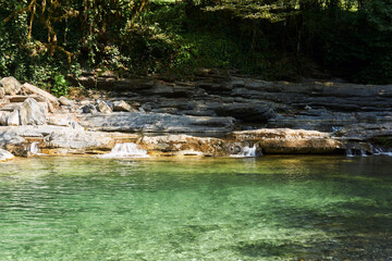 lake on a mountain river with rocky overgrown banks